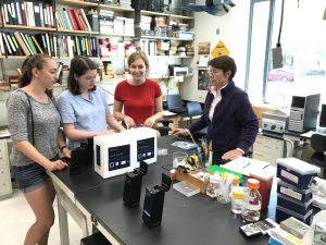 Oberlin College students talk with professor Mary Garvin while preparing to use the Biomeme two3