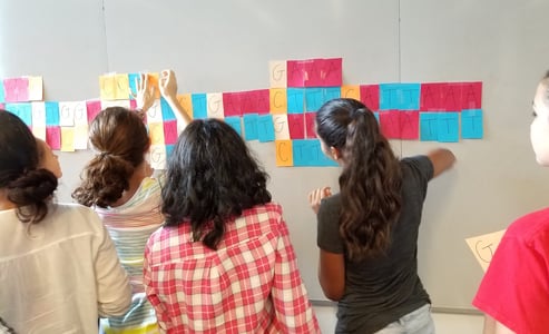 Middle school girls using post-it notes as a hands-on approach in learning about DNA and it's structure.